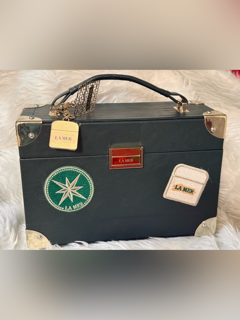 La Mer Black Leather Travel Vanity Case with Gold Accents and Patch Details